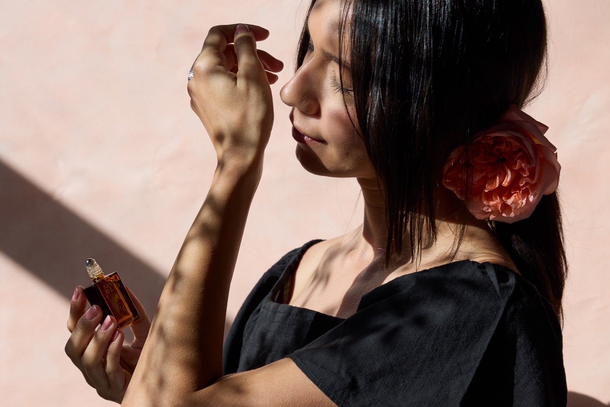 Saint Olio perfume bottle, lifestyle shot, warm shadows, editorial aesthetic.